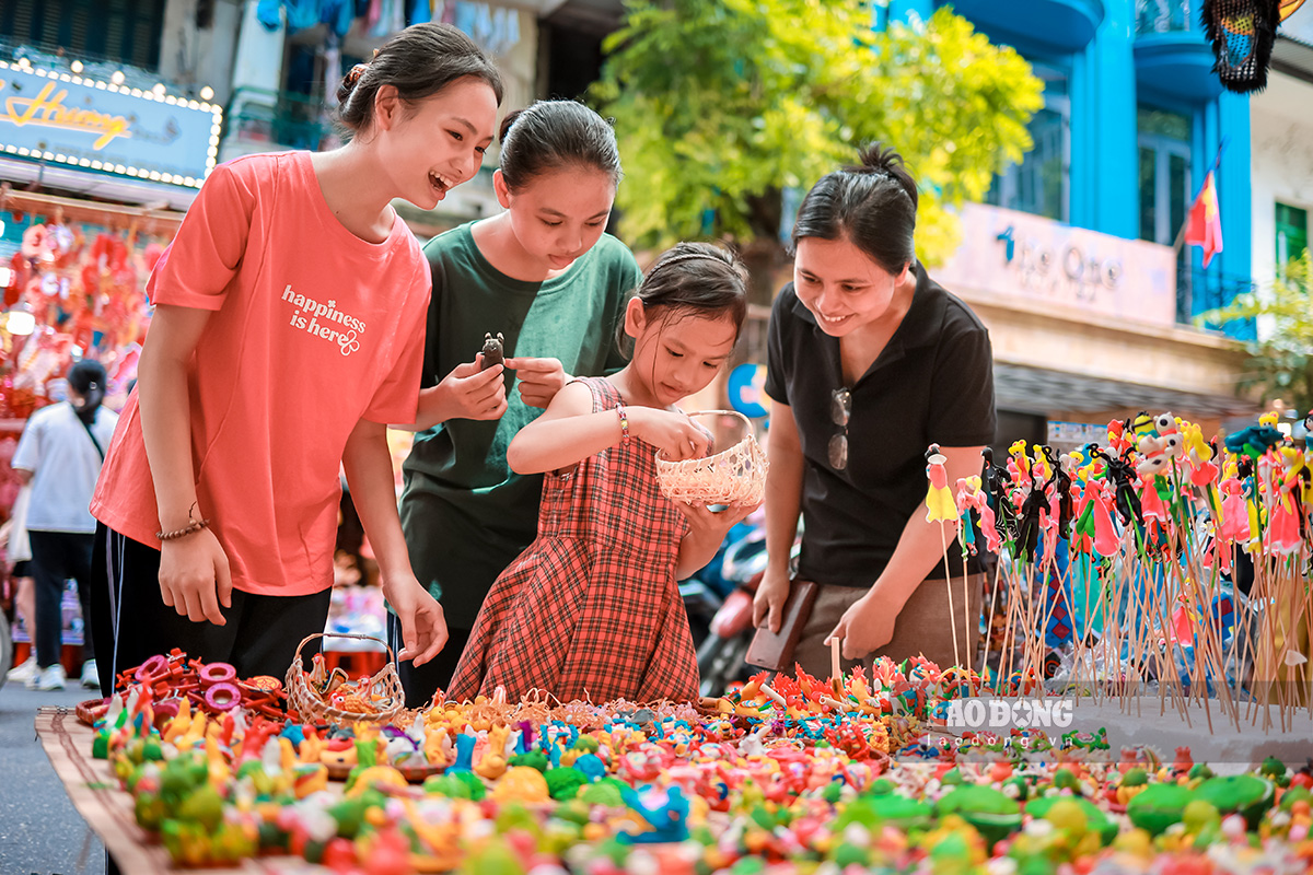 Chị Nguyễn Thị Hương Giang (Hoài Đức, Hà Nội) hạnh phúc khi thấy 3 con gái của mình thích thú với những món đồ chơi hình con thú được làm từ gạo nếp.