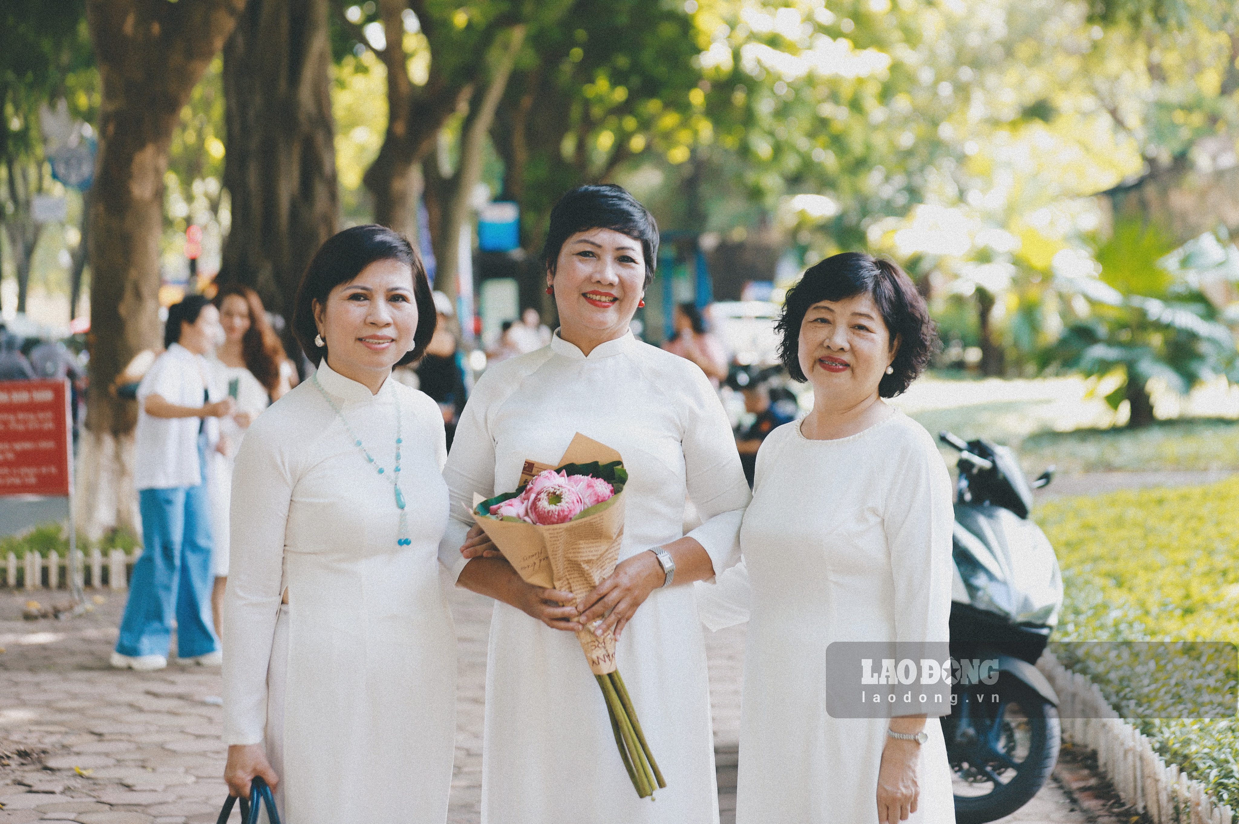 Tại con phố Phan Đình Phùng thấy rõ nhất vẻ đẹp của mùa thu Hà Nội. Hai bên đường, lá cây bắt đầu ngả vàng tạo nên một vẻ đẹp lãng mạn, thơ mộng khiến bất cứ ai cũng xao xuyến. Bà Nguyễn Thị Hồng Phúc (bên trái, ngoài cùng) chia sẻ: “Hôm nay, tiết trời thu Hà Nội rất đẹp. Tôi cùng bạn chọn mặc áo dài để tôn vinh vẻ đẹp của người phụ nữ Việt Nam. Mùa thu đẹp nhưng ngắn ngủi vì vậy chúng tôi phải tranh thủ lưu lại những bức hình đẹp nhất làm kỉ niệm“. 