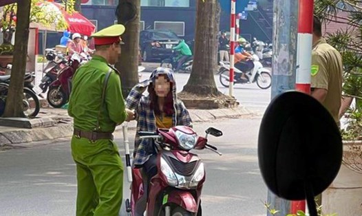 Công an phường ở Hà Nội dừng xe một trường hợp không đội mũ bảo hiểm. Ảnh: D.T
