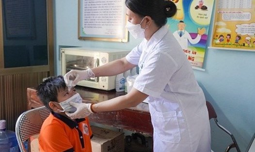Cán bộ y tế trường học tra thuốc và thăm khám cho học sinh mắc bệnh đau mắt đỏ. Ảnh: Sở Y tế tỉnh Hải Dương