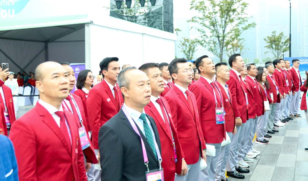 Các thành viên Đoàn thao Việt Nam hát Quốc ca tại lễ thượng cờ. Ảnh: Bùi Lượng 
