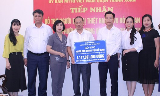 Đại diện UBMTTQ Việt Nam quận Ba Đình (Hà Nội) trao tiền hỗ trợ hơn 1,1 tỉ đồng cho các nạn nhân vụ hỏa hoạn tại chung cư mini ở Khương Hạ. Ảnh: Vân Trang