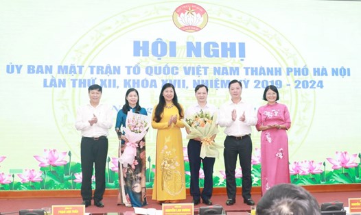 Lãnh đạo Ủy ban MTTQ Việt Nam TP Hà Nội tặng hoa chúc mừng bà Đặng Thị Phương Hoa và ông Trương Văn Nhung. Ảnh: MTTQ Hà Nội