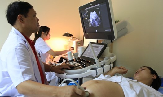 Chuyên gia sản khoa khám cho thai phụ tại Bệnh viện Phụ sản Trung ương - địa điểm sàng lọc trước sinh, sơ sinh hàng đầu. Ảnh: BVCC