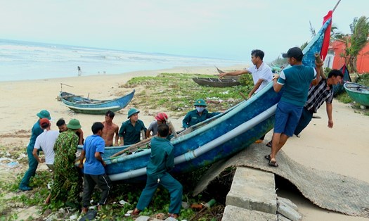 Lực lượng biên phòng giúp ngư dân Tam Thanh đưa phương tiện ghe thuyền vào nơi tránh trú an toàn. Ảnh Hoàng Bin.
