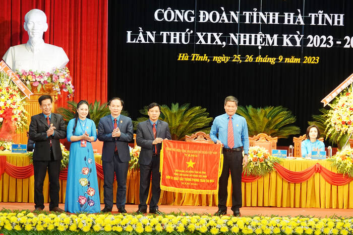 Tại Đại hội, ông Huỳnh Thanh Xuân - Phó Chủ tịch Tổng LĐLĐ Việt Nam đã trao Cờ thi đua xuất sắc của Chính phủ cho LĐLĐ tỉnh Hà Tĩnh. Ảnh: Trần Tuấn.