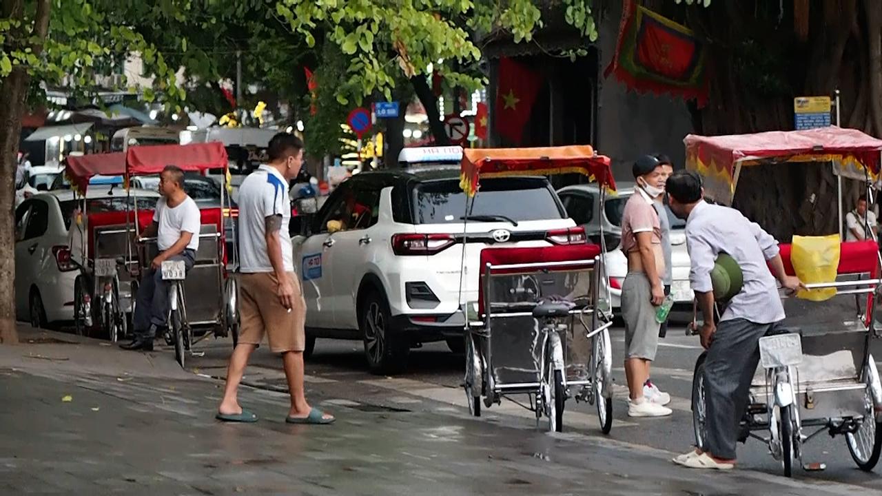 Một số chủ xe xích lô ngồi chờ khách ven Hồ Hoàn Kiếm vào chiều 25.9. Ảnh: Bích Ngọc