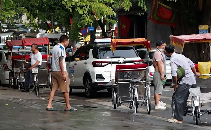 Một số chủ xe xích lô ngồi chờ khách ven Hồ Hoàn Kiếm vào chiều 25.9. Ảnh: Bích Ngọc