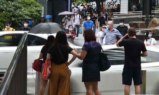 Người và xe ôtô trên đường phố Singapore. Ảnh: Xinhua