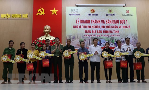 Thứ trưởng Bộ Công an Lương Tam Quang, lãnh đạo tỉnh Hà Tĩnh và nhà tài trợ trao tặng quà và biểu trưng chìa khóa nhà cho các hộ dân ở huyện Hương Khê. Ảnh: TTXVN