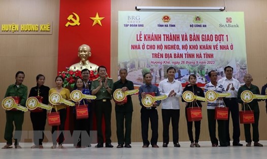 Thứ trưởng Bộ Công an Lương Tam Quang, lãnh đạo tỉnh Hà Tĩnh và nhà tài trợ trao tặng quà và biểu trưng chìa khóa nhà cho các hộ dân ở huyện Hương Khê. Ảnh: TTXVN