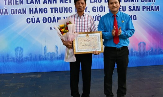 Chủ tịch LĐLĐ Bình Định Hà Duy Trung trao giải nhất cho tác giả Đỗ Văn Đông. Ảnh: Xuân Nhàn.