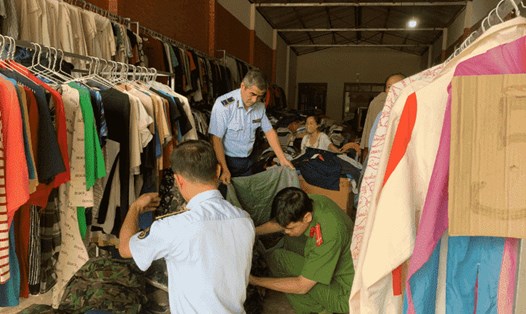Đội QLTT số 3 phối hợp cùng Công an huyện Mộc Châu tiến hành kiểm tra số quần áo vi phạm. Ảnh: Đội QLTT số 3