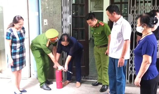 Công an quận Đống Đa hướng dẫn người dân sử dụng bình PCCC. Ảnh: Hanoi.gov