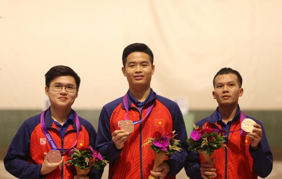 Phạm Quang Huy (giữa) cùng Phan Công Minh và Lại Công Minh nhận huy chương đồng nội dung 10m súng ngắn hơi đồng đội nam. Ảnh: Bùi Lượng