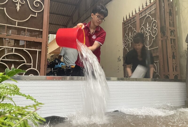 Nhiều nhà dân trong ngõ 204 Trần Duy Hưng bị ngập sâu, họ che chắn, tát nước ra nhưng cơn mưa liên tục không ngừng khiến cho nước vẫn ào ạt đổ về.