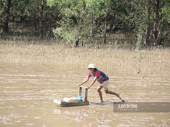 Một ngư dân Mỏ Ó trượt mong trên bãi bồi đi bắt cá. Ảnh: Phương Anh