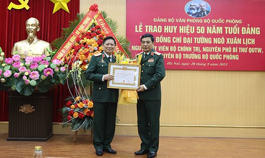Đại tướng Phan Văn Giang trao Huy hiệu 50 năm tuổi Đảng và tặng hoa chúc mừng Đại tướng Ngô Xuân Lịch. Ảnh: BQP