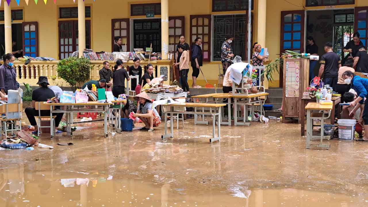 Các giáo viên tranh thủ lau chùi, dọn dẹp bùn đất và sắp xếp đồ dùng dạy học để chuẩn bị đón học sinh trở lại trường. Ảnh: Quang Đại