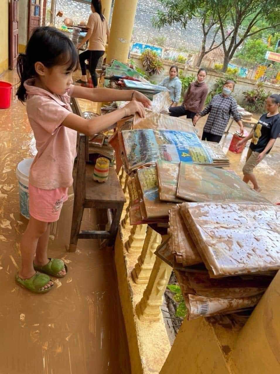 Em học sinh tiểu học ở huyện Quỳ Châu (Nghệ An) buồn bã vì sách vở đã bị mưa lũ làm hỏng hết. Ảnh: Hải Đăng