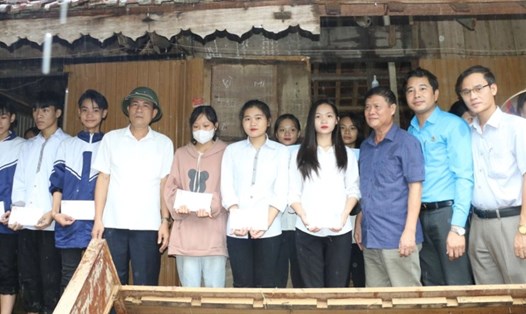 Đoàn công tác trao hỗ trợ cho các học sinh ở trọ bị thiệt hại do lũ lụt. Ảnh: Quỳnh Trang