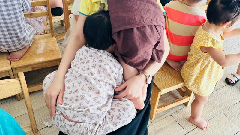 Em bé oà khóc trong vòng tay mẹ khi xem múa lân Tết Trung thu ở trường. Ảnh: Phụ huynh cung cấp