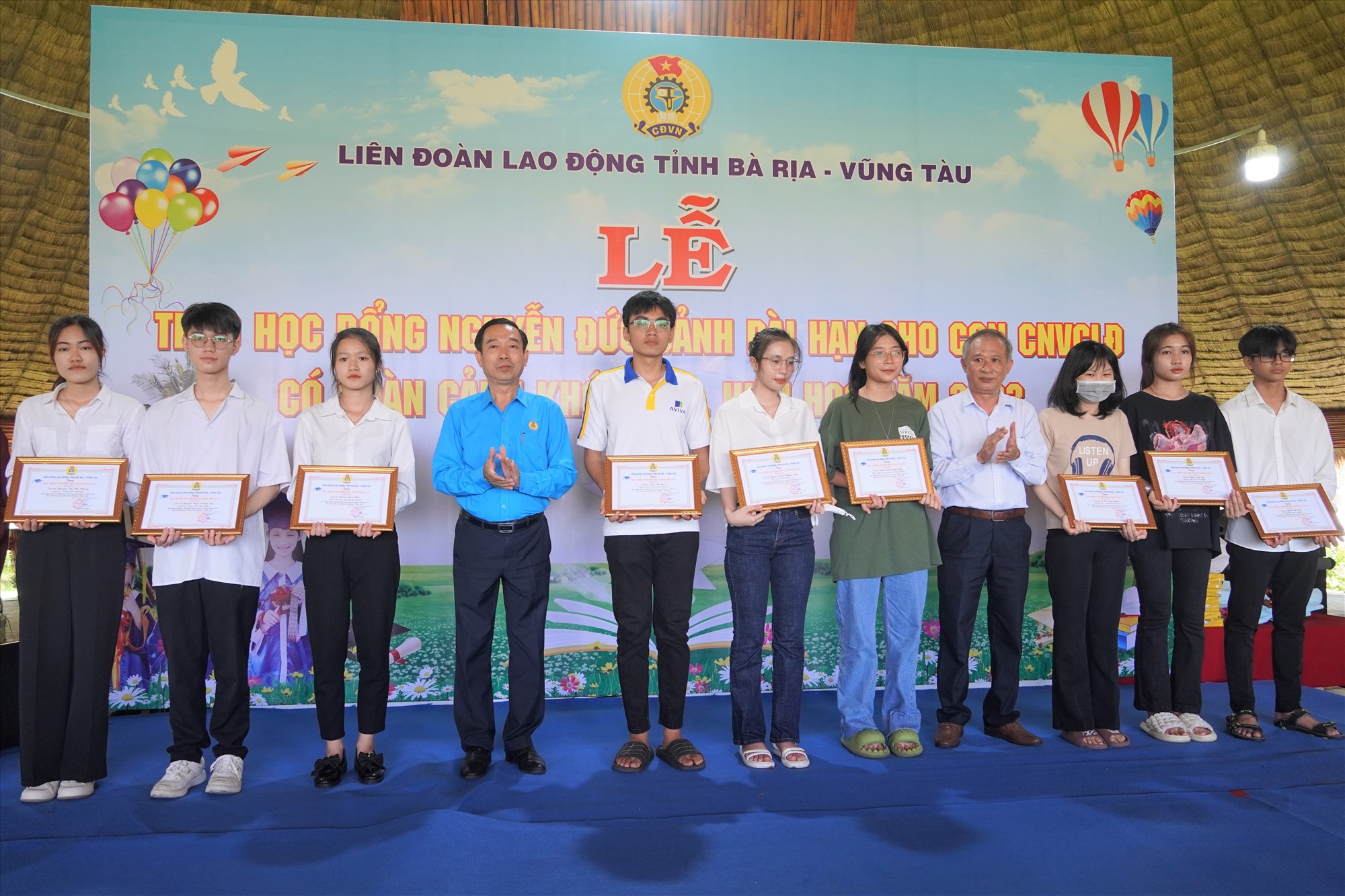 Ông Lê Văn Hòa - Chủ tịch LĐLĐ tỉnh trao học bổng Nguyễn Đức Cảnh cho các em học sinh nghèo vượt khó học giỏi. Ảnh: Thành An