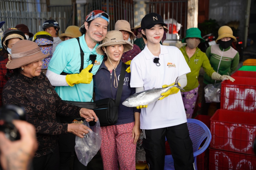 Huy Khánh - Diệp Bảo Ngọc hào hứng bán cá tại chợ. Ảnh: NSX