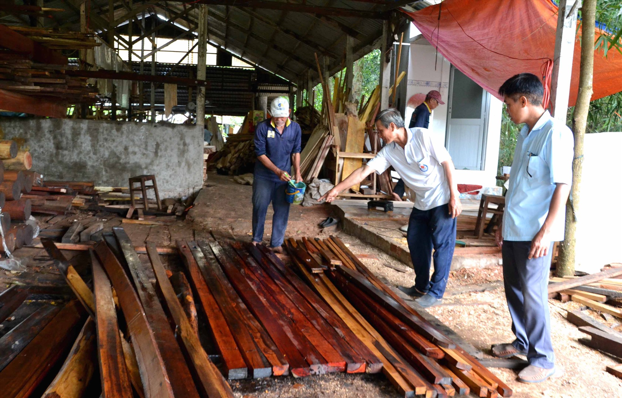 Anh Nguyễn Phước Hoàng (giữa ảnh) cùng các thành viên Tổ Từ thiện ấp Mỹ An 2 xử lý cột gỗ chuẩn bị sửa chữa nhà cho hộ khó khăn, neo đơn. Ảnh: Lâm Điền