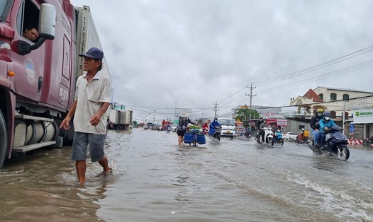Quốc lộ 1A đoạn qua xã Thuận An, thị xã Bình Minh, tỉnh Vĩnh Long dài hơn 500m bị ngập sâu do triều cường dâng cao làm ùn tắc giao thông. Ảnh: Hoàng Lộc
