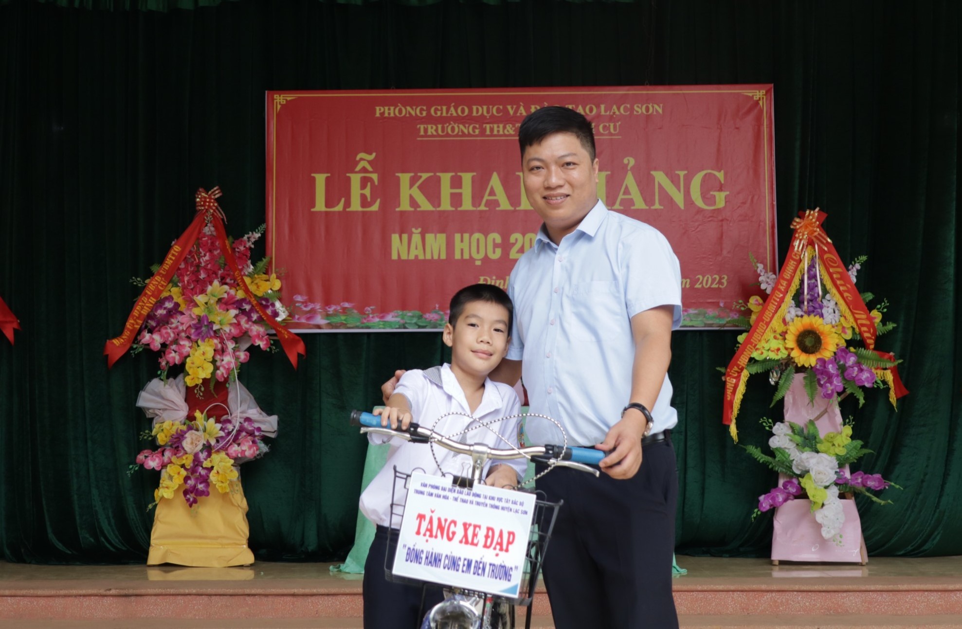 PV Minh Chuyên - Văn phòng Đại diện Báo Lao Động - Tây Bắc Bộ trao xe đạp đến học sinh. Ảnh: Minh Tùng. 