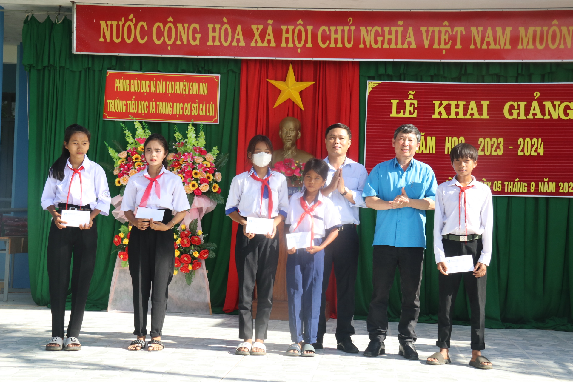 Lãnh đạo LĐLĐ tỉnh Phú Yên và Tổng Công ty Khánh Việt trao học bổng cho các em học sinh trường TH&THCS Cà Lúi tại lễ khai giảng. Ảnh: Phương Linh