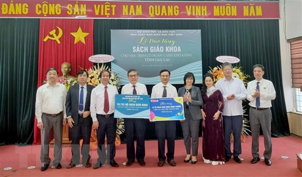 Đại diện Nhà xuất bản Giáo dục Việt Nam trao tặng bộ sách giáo khoa và Tủ sách dùng chung cho tỉnh Gia Lai. Ảnh: TTXVN