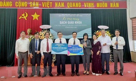 Đại diện Nhà xuất bản Giáo dục Việt Nam trao tặng bộ sách giáo khoa và Tủ sách dùng chung cho tỉnh Gia Lai. Ảnh: TTXVN