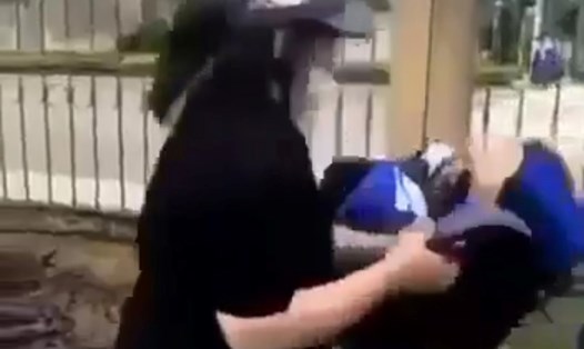 Nữ sinh bị một người dùng mũ bảo hiểm đánh tới tấp vào đầu. Ảnh cắt từ video.