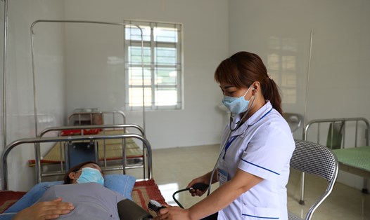 Cán bộ dân số ở Hòa Bình thực hiện nhiệm vụ của cán bộ y tế khác tại trạm y tế. Ảnh: Thùy Linh