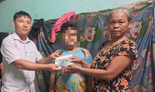 Phóng viên Báo Lao Động trao số tiền hỗ trợ 10 triệu đồng (tiền hỗ trợ của bạn đọc) cho bà Thị Nhu. Ảnh: Hai Lập