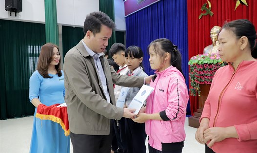 Ông Nguyễn Thế Mạnh - Tổng Giám đốc BHXH Việt Nam tặng thẻ BHYT cho học sinh có hoàn cảnh khó khăn. Ảnh: hà anh