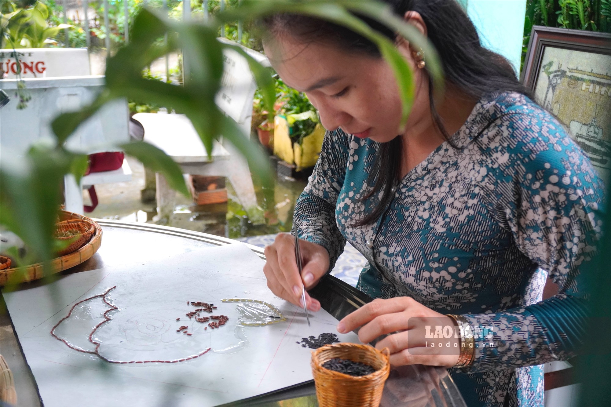 Tuyết Phượng tỉ mẩn với từng đường nét trên tranh. Ảnh: Nguyên Anh