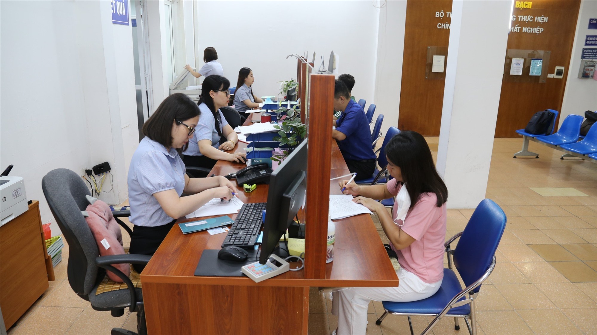 Cán bộ Trung tâm Dịch vụ việc làm Hà Nội hướng dẫn người dân làm thủ tục nhận trợ cấp thất nghiệp. Ảnh: Hạnh Hà. 