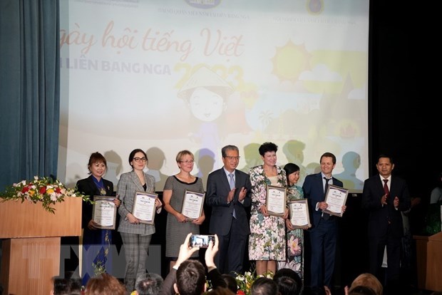 Đại sứ Đặng Minh Khôi (giữa) trao thư cảm ơn cho các giảng viên làm công tác giảng dạy tiếng Việt ở các trường Đại học của Nga. Ảnh: TTXVN