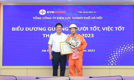 Ông Nguyễn Anh Tuấn - Chủ tịch Hội đồng thành viên Tổng Công ty Điện lực Hà Nội trao tặng bằng khen UBND Thành phố Hà Nội cho anh Hoàng Công Khánh. Ảnh: Hồng Anh