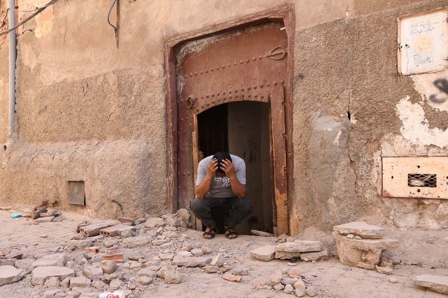 Một người dân ngồi trước ngôi nhà bị hư hại ở Marrakesh, ngày 9.9.2023. Ảnh: Xinhua