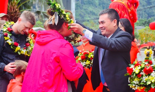 Giám đốc Sở Du lịch Quảng Bình Nguyễn Ngọc Quý tặng hoa chúc mừng vị khách đầu tiên đến với Phong Nha - Kẻ Bàng. Ảnh: Tâm Đức