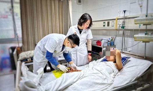 Các bác sĩ Bệnh viện Hữu nghị Việt Đức thăm khám cho bệnh nhân bị dập nát tay do pháo tự chế. Ảnh: Bệnh viện cung cấp
