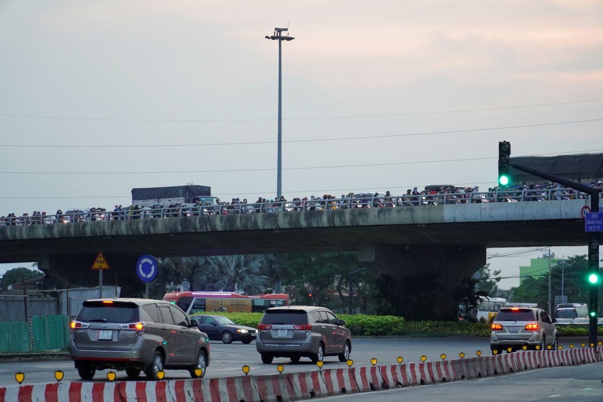 “Từ chiều nay lượng phương tiện đông nhưng không tắc, chỉ đến gần tối mới tắc“, ông Nguyễn Văn Hà, làm nghề xe ôm tại đây cho biết. Hình ảnh dòng phương tiện nối đuôi nhau di chuyển chậm trên cầu vượt Bình Thuận. 