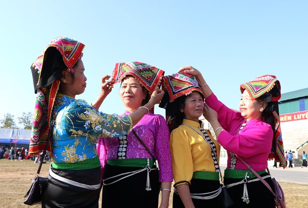 Những người phụ nữ dân tộc Thái chỉnh sửa trang phục để đi chơi ngày đầu năm. Ảnh: TTXVN