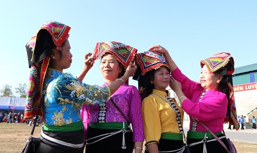 Những người phụ nữ dân tộc Thái chỉnh sửa trang phục để đi chơi ngày đầu năm. Ảnh: TTXVN