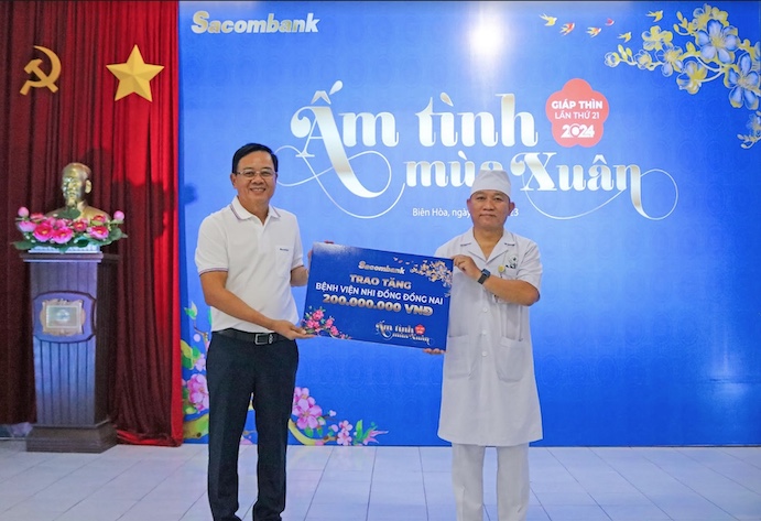 Ông Phạm Thanh Kỳ – Giám đốc Khu vực Đông Nam Bộ Sacombank trao biểu trưng hỗ trợ cho ông Lê Anh Phong – Giám đốc Bệnh viện Nhi đồng Đồng Nai. Ảnh: STB