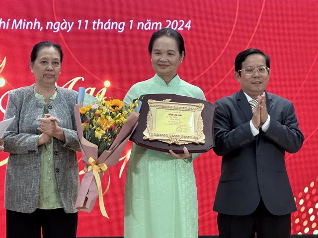 Vì ở xa, nhà văn Nguyễn Thị Minh Ngọc đã ủy nhiệm cho nhà văn Bích Ngân - Chủ tịch Hội Nhà văn TP.HCM (áo dài) nhận thay. Ảnh: DiPy.